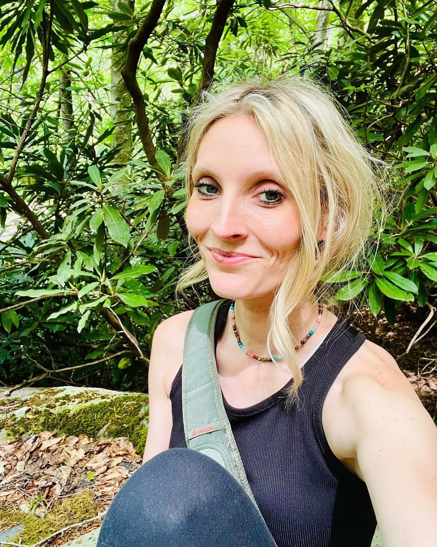 Portrait selfie of Nicole framed by rhododendron in Appalachia